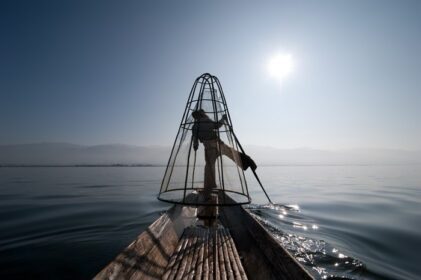دانلود ماهیگیر برمه در قایق بامبو ماهیگیری می کند که در راه سنتی با شبکه دست ساز کار می کند. دریاچه Inle، میانمار (برمه) مقصد سفر