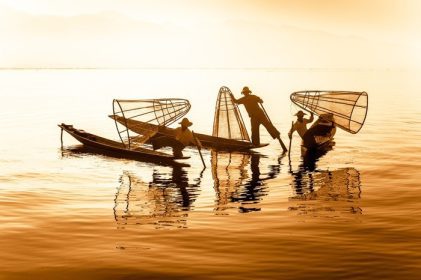 دانلود ماهیگیر برمه در قایق بامبو ماهیگیری می کند که در راه سنتی با شبکه دست ساز کار می کند. دریاچه Inle، میانمار (برمه) مقصد سفر