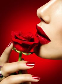 دانلود مدل زن زیبا بوسیدن گل رز قرمز. لب قرمز، ناخن و رز. دختر زیبایی آرایش و مانیکور جسمی
