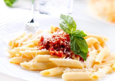 دانلود ماکارونی پونه ماکارونی با سس بولونی ، پنیر پارمزان و ریحان روی یک چنگال. غذاهای ایتالیایی. غذای مدیترانه ای