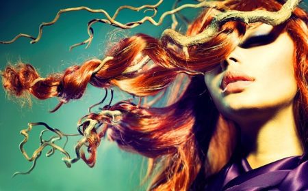 دانلود موی قرمز. پرتره زنانه مدل مد با موهای قرمز بلند مجعد در شاخه های چوبی. فصل پاييز. اکستنشن مو