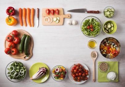 دانلود مفهوم خوردن سالم با سبزیجات تازه و کاسه های سالاد روی میز چوبی آشپزخانه ، فضای کپی در مرکز ، نمای بالا
