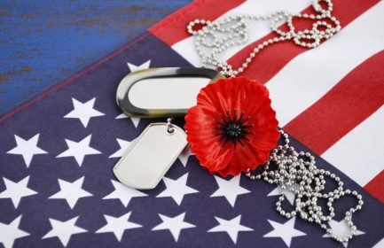 دانلود مفهوم روز یادبود ایالات متحده آمریکا با برچسب سگ و خشخاش یادبود قرمز در ستاره های آمریکایی و پرچم راه راه در جدول چوب پرنعمت آبی تیره.
