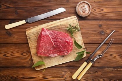 دانلود فیله گوشت خام گوشت گاو خام روی میز چوبی با چنگال گوشت و وزن 1 عیار آهن