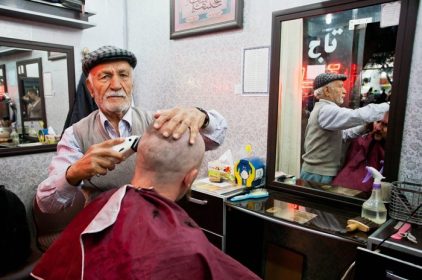 دانلود یازد ، ایران – اکتبر 20 آرایشگر سالمند مشتری را در سالن موهای کوچک در 20 اکتبر 2014 در خاور میانه بریده و تراشیده است. جمعیت یزد نزدیک به 2 است