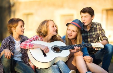 دانلود پرتره نوجوانان مبارک که گیتار را با دوستان خود احاطه کرده اند