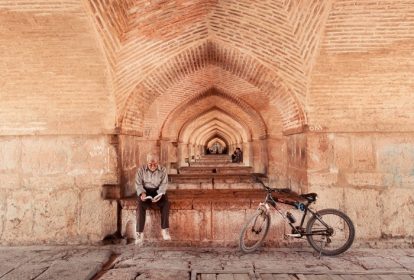 دانلود اصفهان ، ایران – 15 اکتبر پیرمردی یک رمان را با دوچرخه خود در زیر پل معروف خواجو در 15 اکتبر 2014 خواند. G