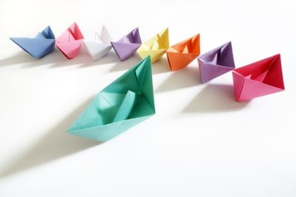 دانلود قایق های کاغذی از چند رنگ به دنبال یک ایده قایق رهبر برای رهبری ، کار تیمی و موفقیت پیروزی