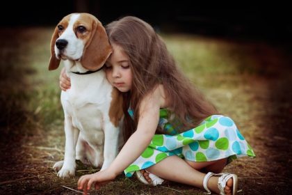 دانلود دختر کوچک در بیرون از خانه سگ را در آغوش می گیرد