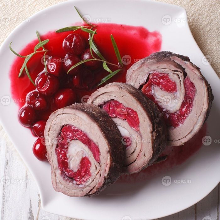 دانلود گوشت پر شده با گیلاس و سس را در یک بشقاب نزدیک می بندیم. نمایی از بالا