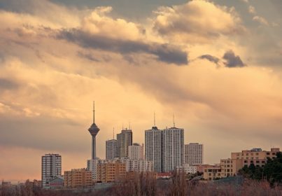دانلود برج میلاد در میان آسمان خراش های بلند مرتفع در آسمان تهران در غروب