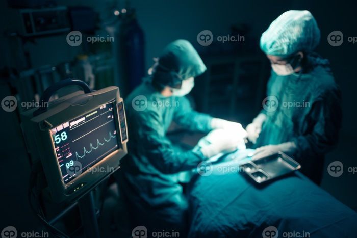 دانلود تیم جراحان با نظارت بیمار در اتاق عمل جراحی همکاری می کنند. تمرکز انتخابی در Monitor