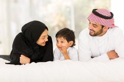 دانلود خانواده جوان مسلمان شاد که سه نفر در خانه در رختخواب دراز کشیده اند