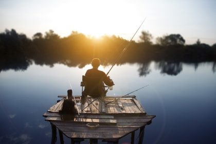 دانلود ماهیگیر در اوایل صبح در دریاچه مشغول ماهیگیری است