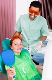 دانلود زن خوشحال بیمار که برای دندانپزشکی به دندانپزشک مراجعه می کند