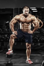 دانلود مرد بدنساز عضلانی ورزشکار عضلات خود را در ورزشگاه نشان می دهد
