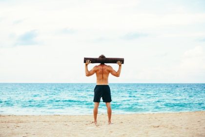 دانلود تمرین ساحلی ورزشکار مرد ورزشکار خارج از منزل در ساحل با ورود درخت. تناسب اندام و شیوه زندگی سالم