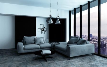 دانلود گوشه ای راحت در یک اتاق نشیمن در اتاق مدرن و بزرگ با نیمکت های نیمه قیمتی خاکستری در مقابل یک پنجره نمایش از کف تا سقف. 3D R