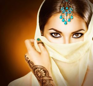 دانلود پرتره دختر زیبا عربی زن جوان هندو با تندی مندی از حنا سیاه در دستانش. پرتره