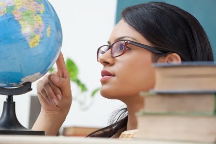 دانلود دانشجوی دختر دانشگاهی که به یک کره زمین نگاه می کند