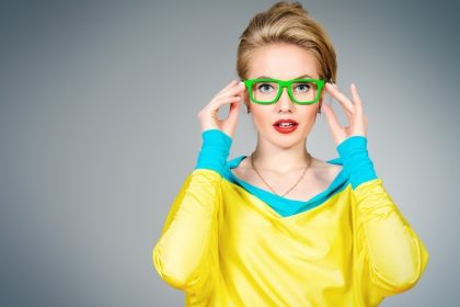دانلود پرتره کلوزآپ یک زن جوان زیبا که در لباس ها و عینک های رنگارنگ و واضح قرار گرفته است. مد روشن. اپتیک ، عینک. شلیک استودیو