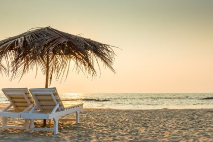 دانلود صندلی های خالی زیر چترهای خاردار در ساحل شنی