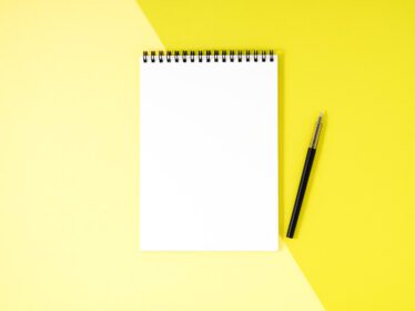 دانلود عکس صفحه سفید دفترچه یادداشت خالی در زمینه رنگی میز زرد