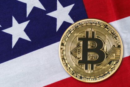 دانلود عکس از نزدیک سکه بیت کوین طلا بر روی پرچم ایالات متحده آمریکا
