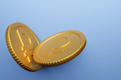 دانلود عکس سکه طلایی با علامت روبل جدا شده در پس زمینه آبی