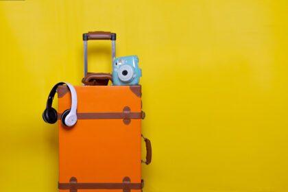 دانلود عکس چمدان نارنجی با هدفون بی سیم و دوربین مینی