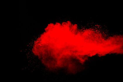 دانلود عکس ابر انفجار پودر قرمز در پس زمینه سیاه انجماد