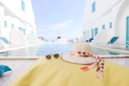 دانلود عکس کلاه تابستانی و عینک آفتابی روی کیسه لوبیا زرد با استخر