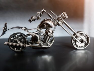 دانلود عکس موتور سیکلت اسباب بازی ساخته شده از فلز در زمینه تیره