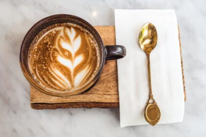دانلود عکس یک فنجان قهوه لاته نمای بالا با فوم شکل برگ