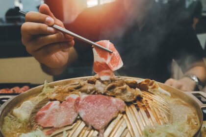 دانلود عکس مرد آسیایی در حال خوردن غذای یاکینیکو نسخه ژاپنی زبان کره ای