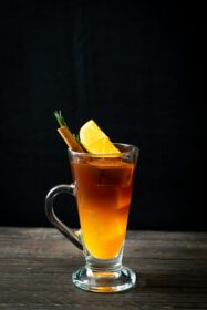 دانلود عکس یک لیوان قهوه سیاه آمریکایی سرد و یک لایه آب پرتقال و لیمو با تزئین رزماری و دارچین