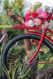 دانلود عکس گل مصنوعی زیبا روی دوچرخه عتیقه قرمز