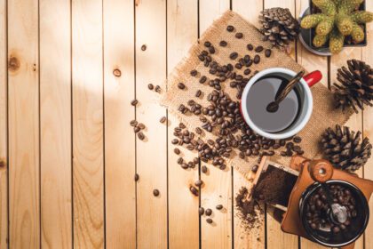 دانلود عکس قهوه سیاه و دانه قهوه روی میز پس زمینه چوبی