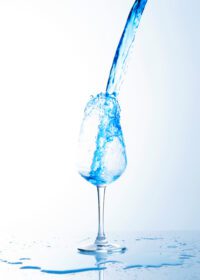 دانلود عکس پاشیدن نوشیدنی آبی به لیوان شراب