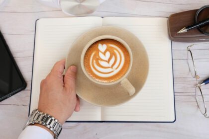 دانلود عکس تاجر در حال نوشیدن قهوه و فضای کار