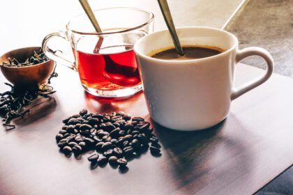 دانلود عکس قهوه و چای با دانه قهوه و برگ چای روی کف چوبی