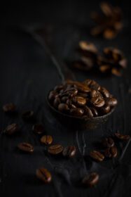دانلود عکس دانه های قهوه در یک قاشق قدیمی در نمای زاویه پس زمینه مشکی