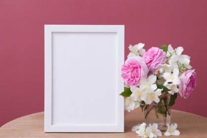 دانلود عکس ماکت قاب سفید خالی با گل در پس زمینه صورتی