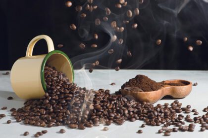 دانلود عکس فنجان قهوه و دانه های اسپری شده و آسیاب شده قهوه در یک چوب