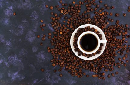 دانلود عکس فنجان قهوه و دانه های قهوه در نمای بالا پس زمینه تیره