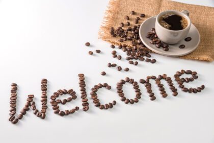 دانلود عکس فنجان قهوه و متن از دانه های قهوه جدا شده روی سفید