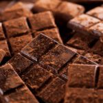 دانلود وکتور تاکسی آنلاین مفهومی ماشین تاکسی زرد و گوشی هوشمند در دست با اپلیکیشن تاکسی در تصویر وکتور پس زمینه شهر به سبک مسطح