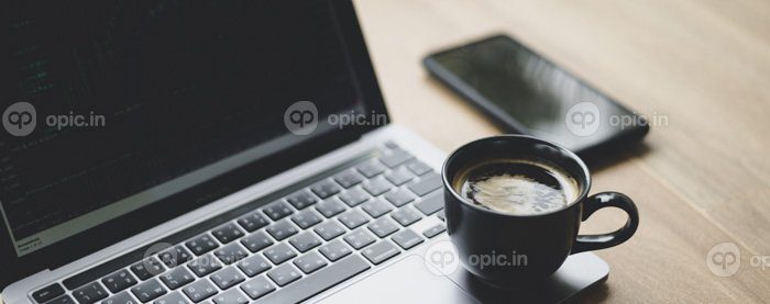 دانلود عکس لیوان قهوه قرار داده شده بر روی لپ تاپ با نمودار استوک روی صفحه نمایش از نزدیک شات