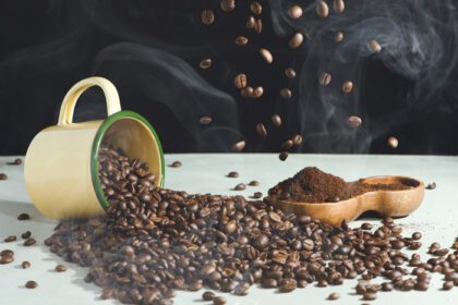 دانلود عکس فنجان قهوه و دانه های اسپری شده و آسیاب شده قهوه در یک چوب