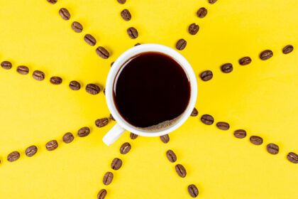 دانلود عکس فنجان قهوه سیاه در پس زمینه زرد با قهوه
